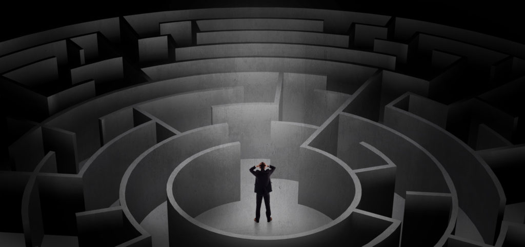 Businessman choosing between entrances in a middle of a dark maze